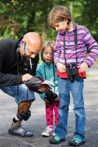 Naturalist David Wright helps two young birdwatchers