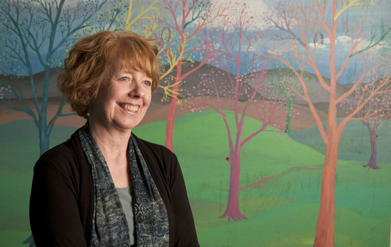 Betsie Norris standing in front of mural by Stephanie Miller-Davis