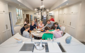 View of a renovated Shaker kitchen with teenagers at the table.