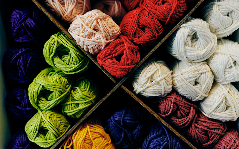 Colorful array of yarns on shelf