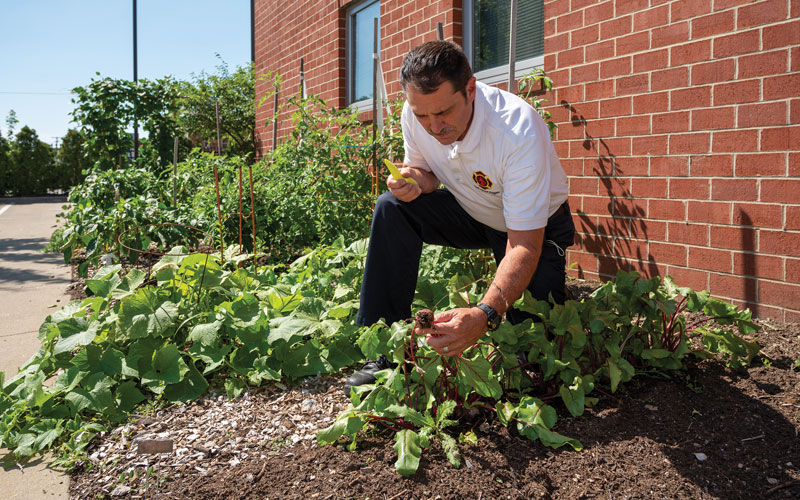 Battalion Chief Frank Zugan works in the garden at Fire Station 1.