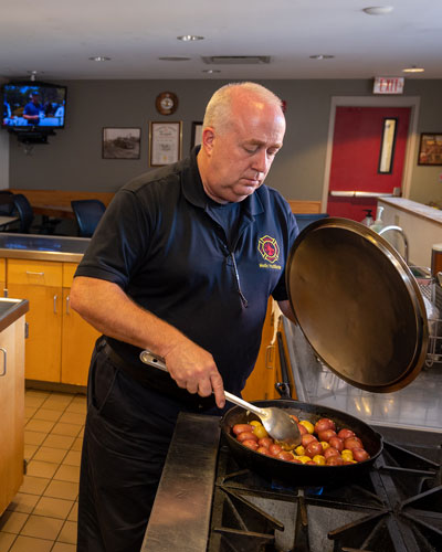 Firefighter Chuck Huddleston prepares the community meal.