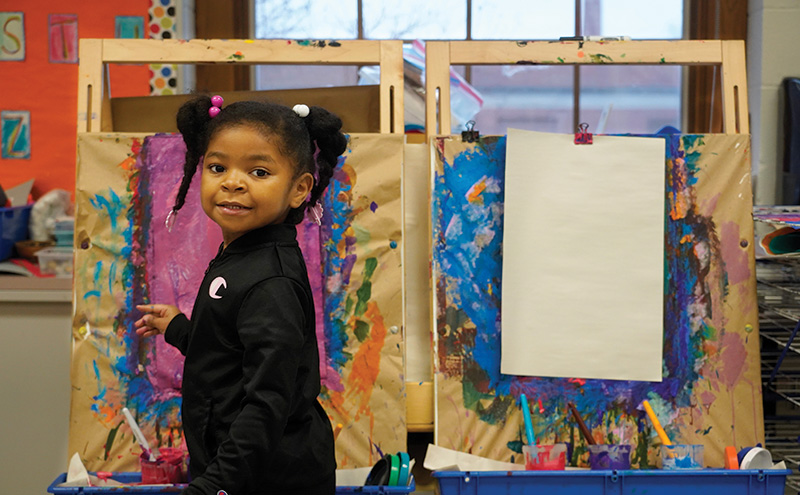 Preschool student at a paint easel