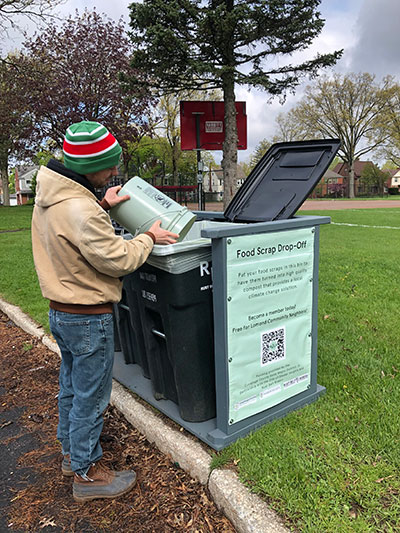 In 2023, the City launched a pilot drop-off composting program in the Lomond neighborhood. Photo of man using the bins.