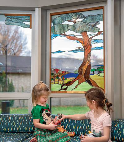 Girls play in front of the stained glass window in the children’s area. 