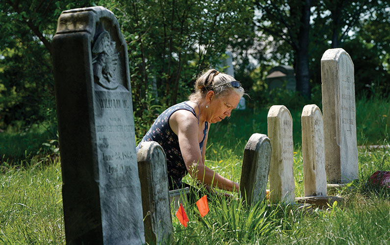 Massachusetts-based emetery restoration expert TaMara Conde at work restoring gravestones in Warrensville West Cemetery.