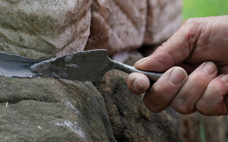 Close up of work to re-attach headstone to base