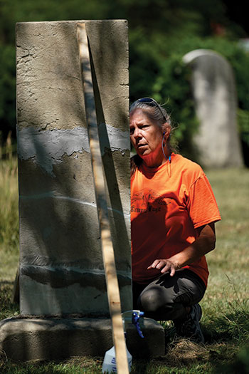 Cemetery restoration expert TaMan Conde replaces a stone she repaired after finding i in pieces