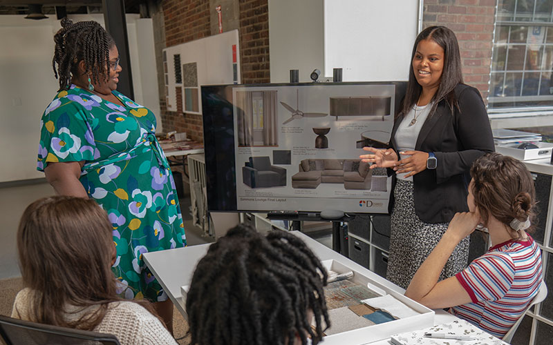 Group meeting around the table in Desired Design's new space