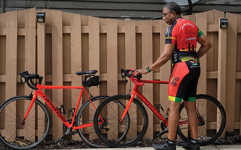 George Couleter leaning a bike up against a fence