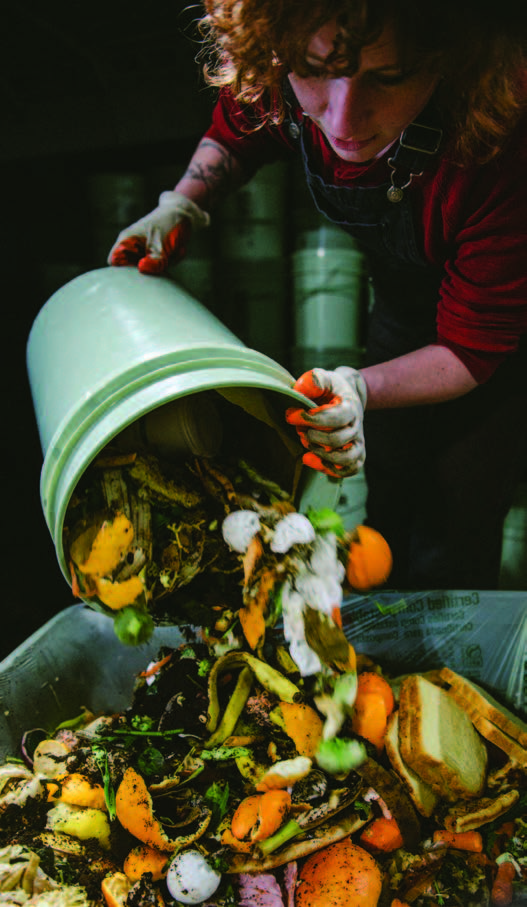 Person dumping compost out of Rust Belt Riders pail