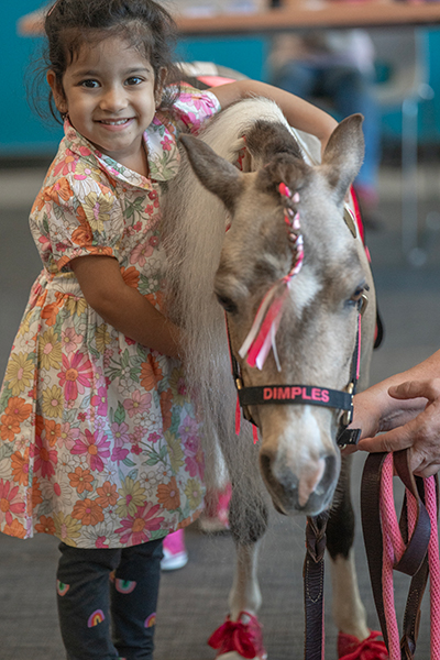 Young girl with miniature horse at Shaker Library
