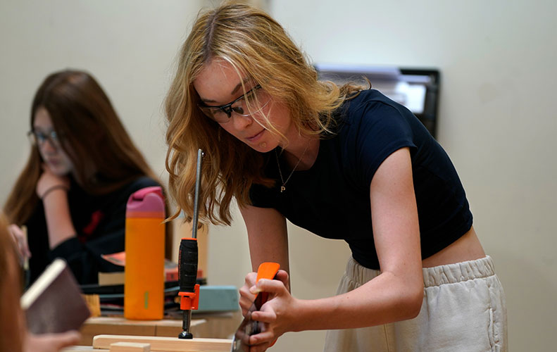 Female high school student working in machine shop