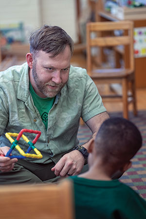 Teacher working with student at Hana Perkins