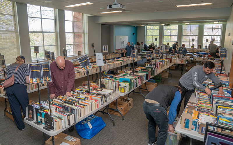 Library book sale with tables full of books