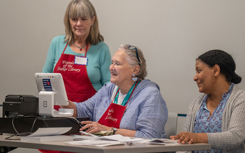 Volunteers working the cash register at the annual book sale